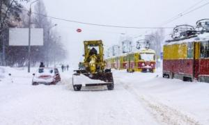 Столичні прибиральники зсипають вантажівки снігу на узбіччя доріг