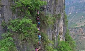 Діти з китайського села добираються до своєї школи по драбинах на прямовисній скелі (фото)